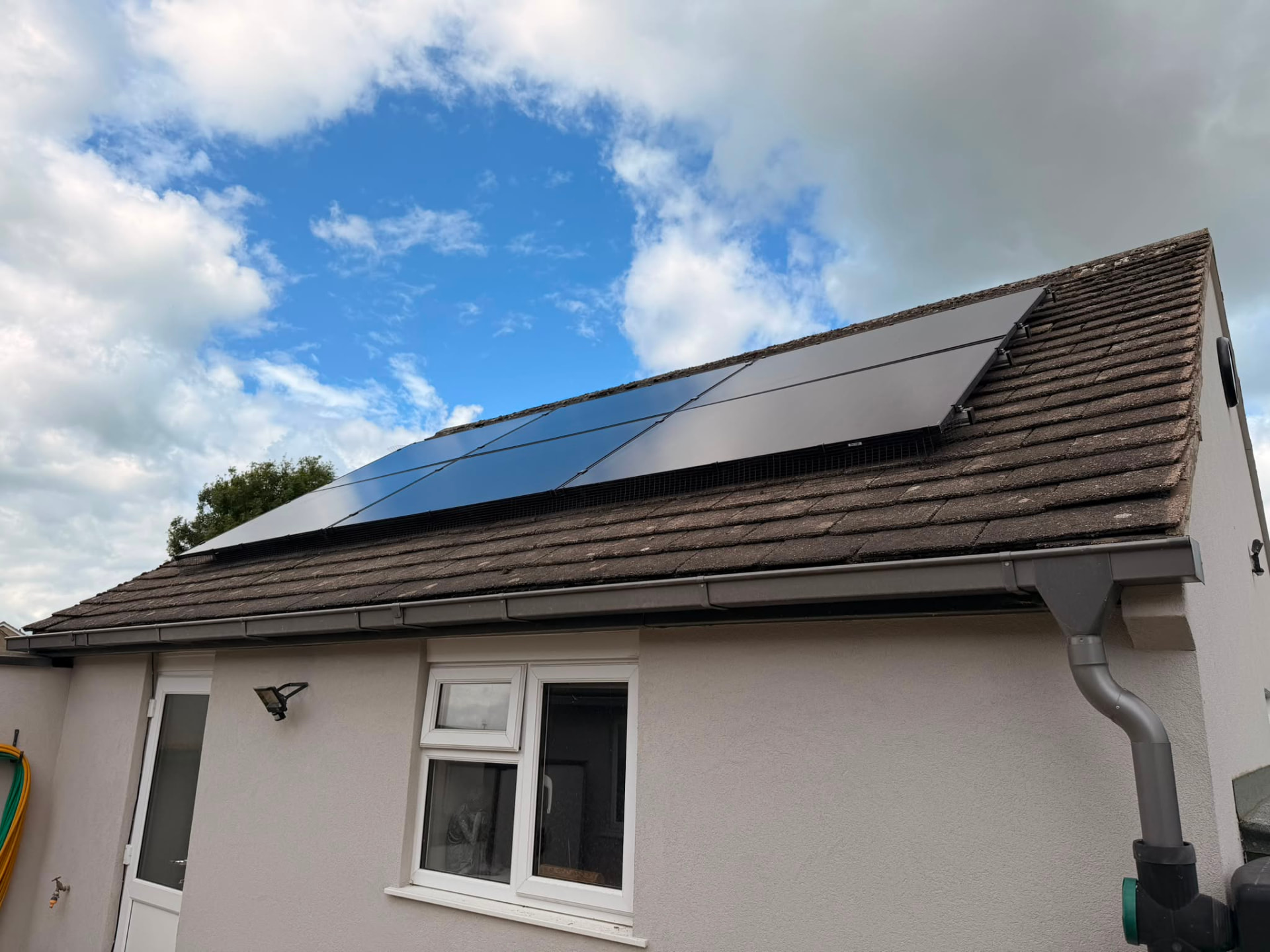 Angled view of solar panels along the pitch of a tiled roof
