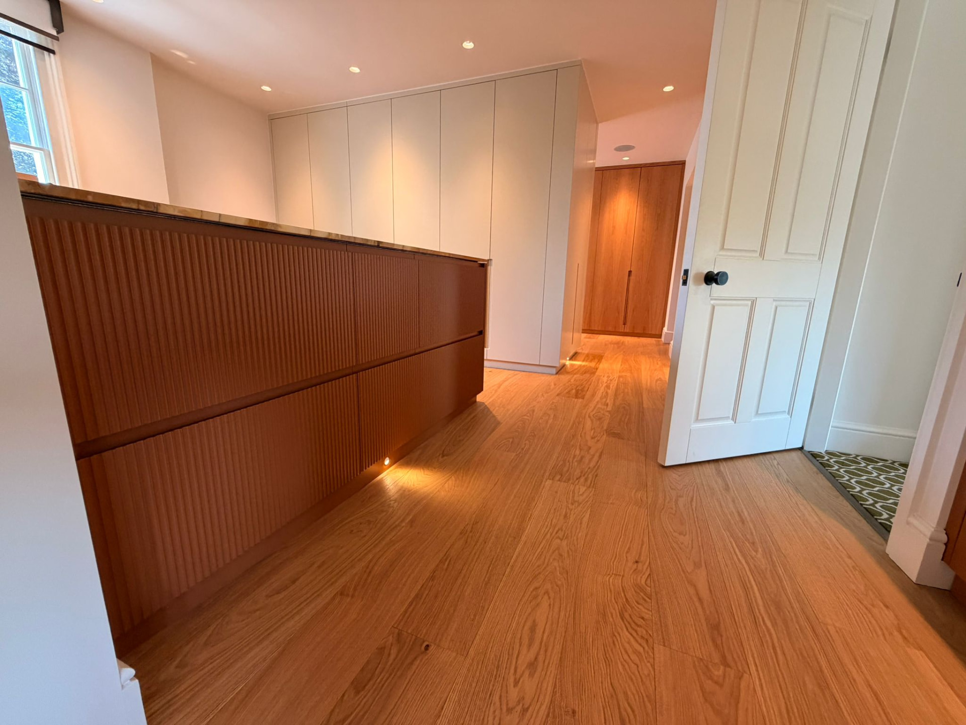Landing with fitted joinery and directional floor-level lighting