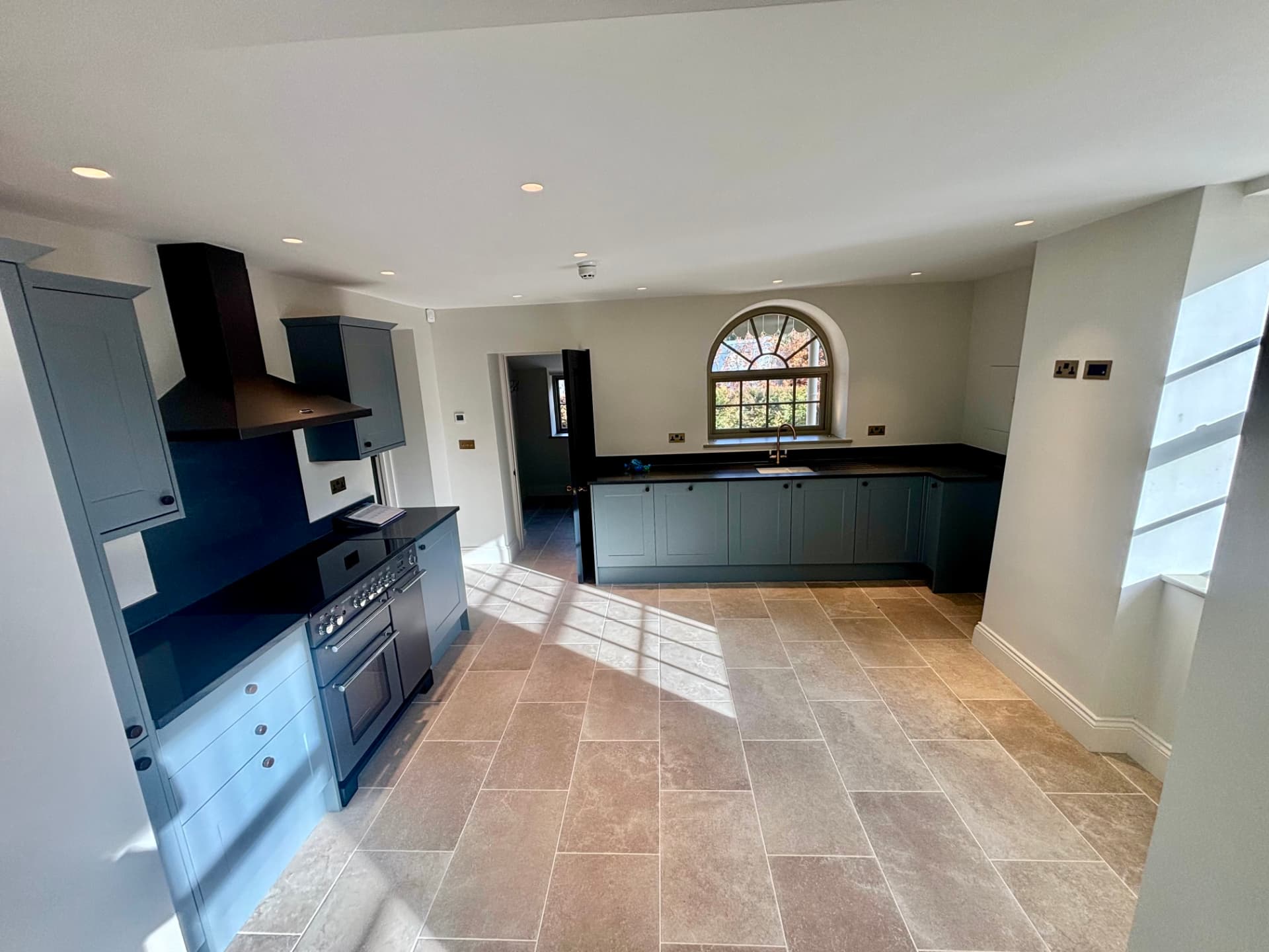 Kitchen with dark blue cabinetry, downlights and antique brass sockets