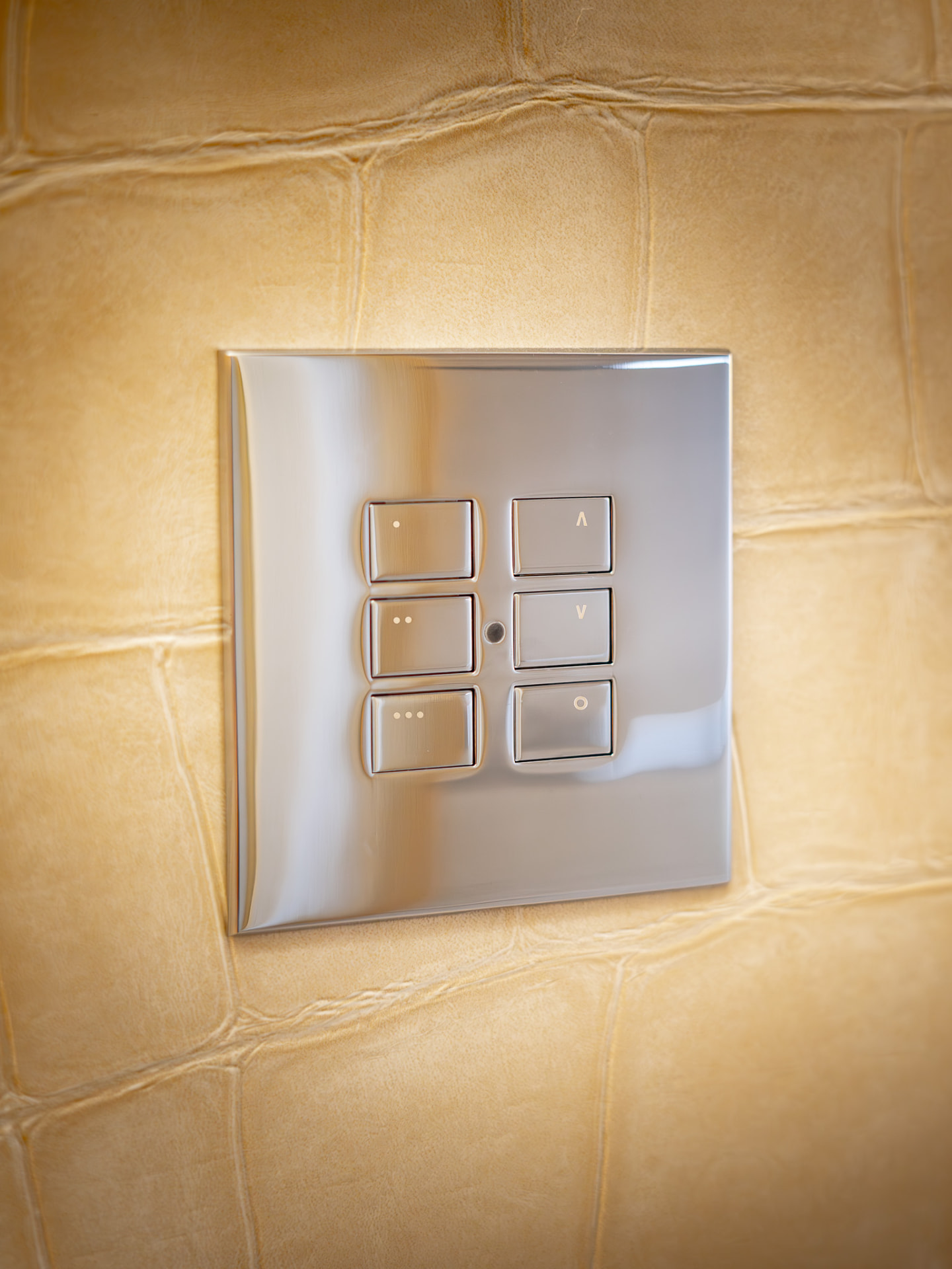 Antique brass lighting keypad and socket plate mounted on a plaster wall