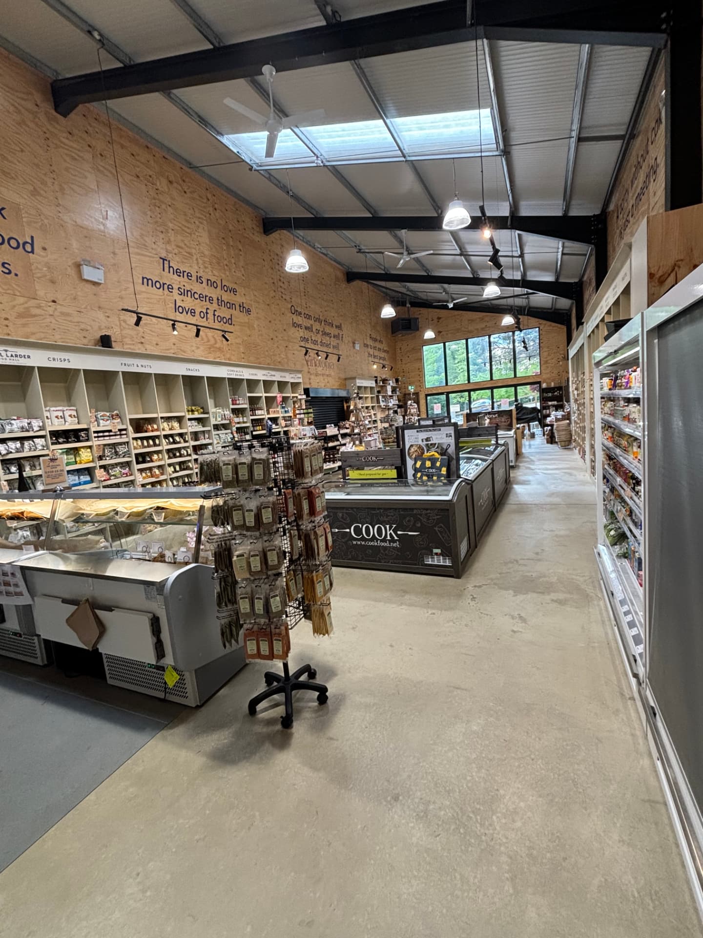 Food hall aisle with chilled cabinets, pendants and rooflights
