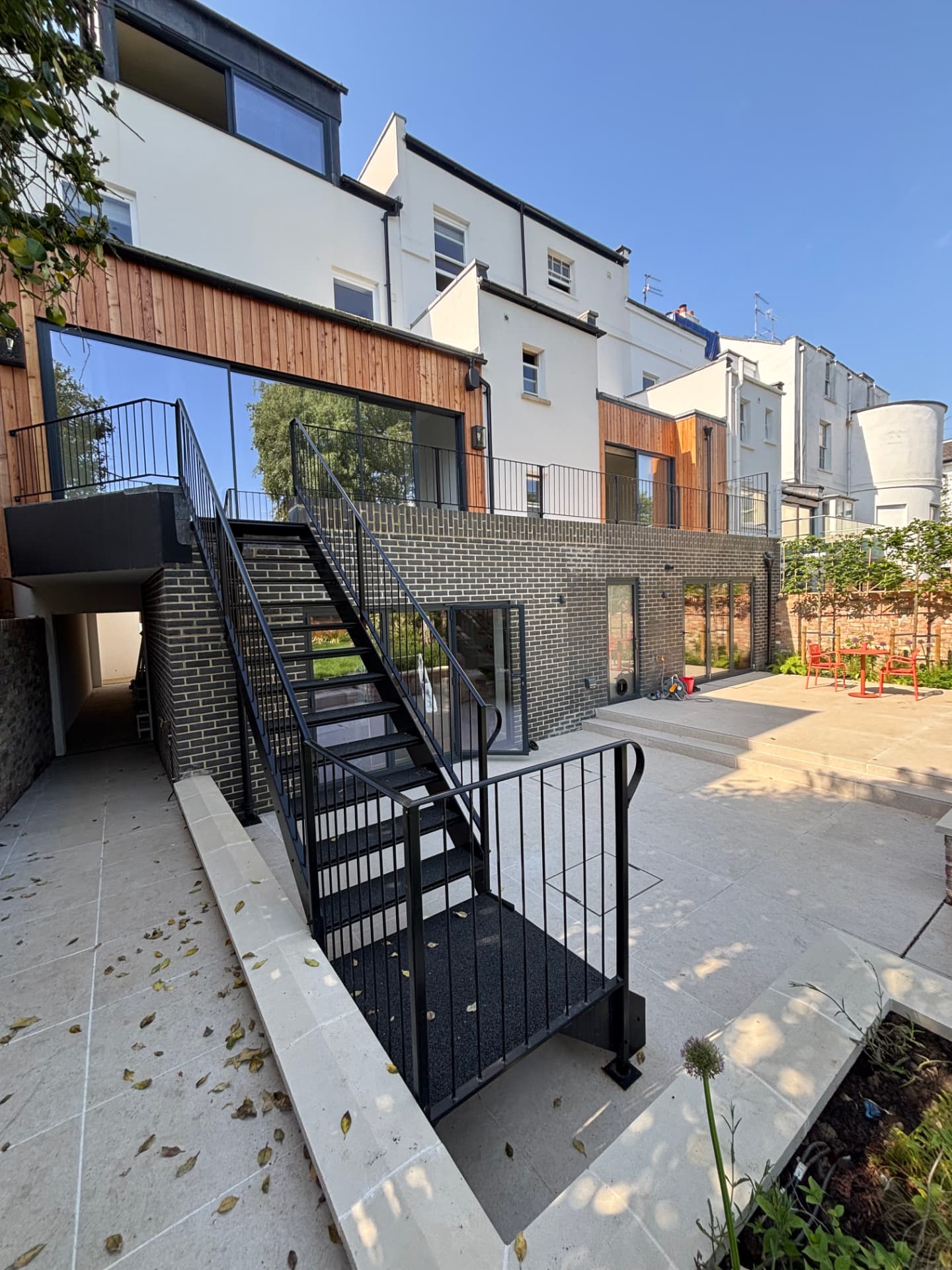 Rear elevation of the townhouse with terrace, external steps and garden lighting