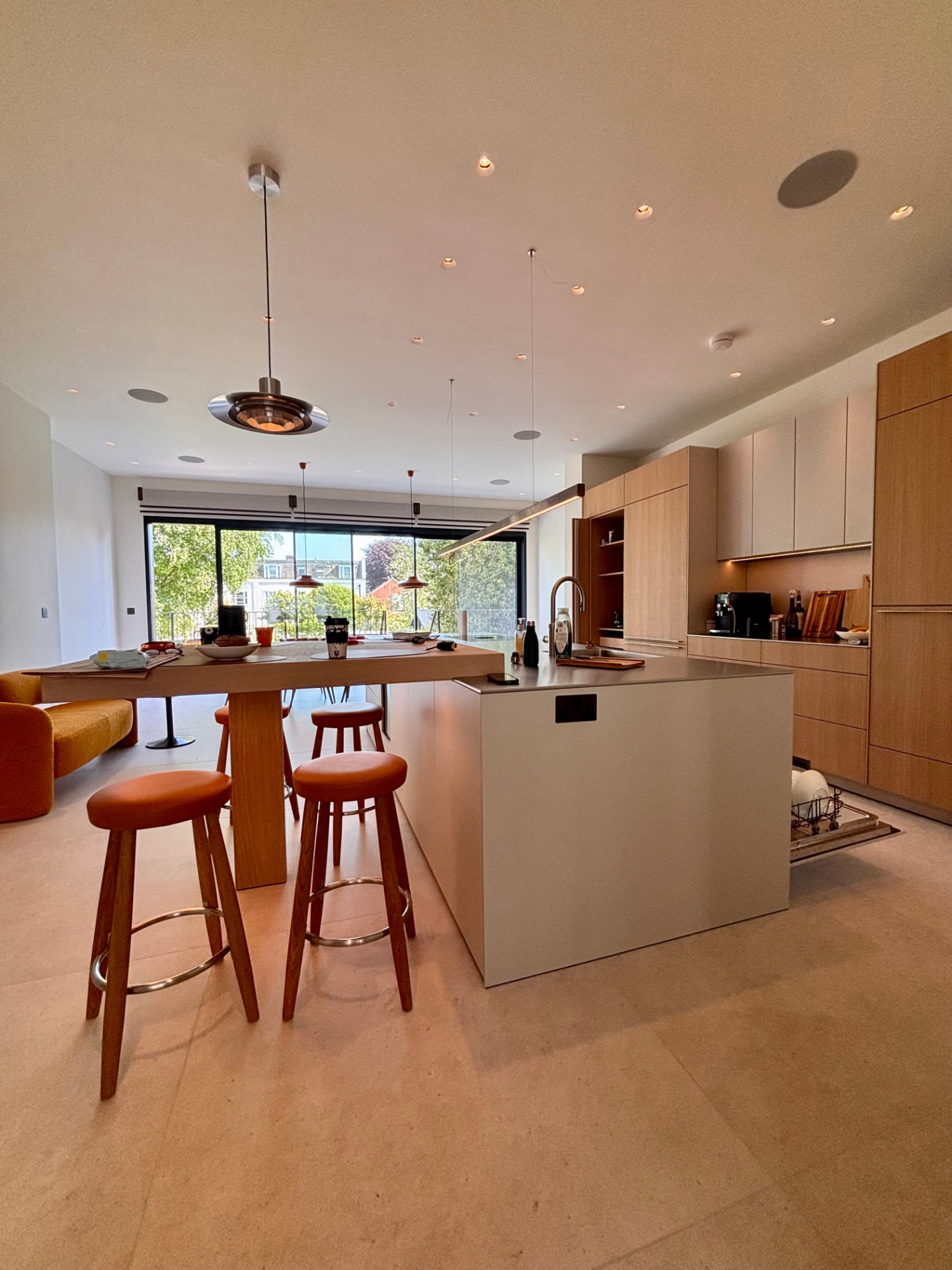 Kitchen island with pendant lighting above and illuminated cabinetry beyond