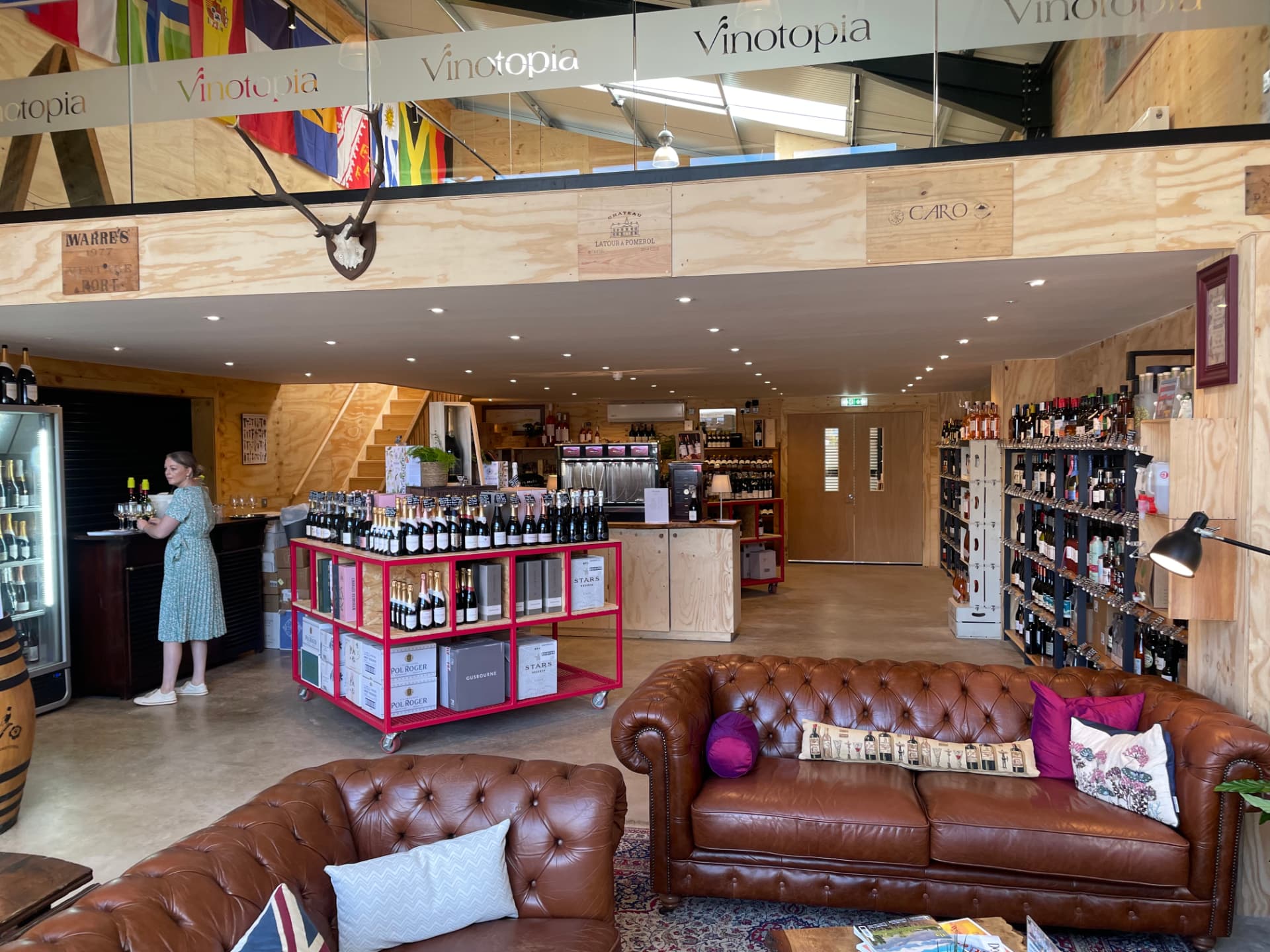 Vinotopia wine shop interior with mezzanine, downlights and seating area