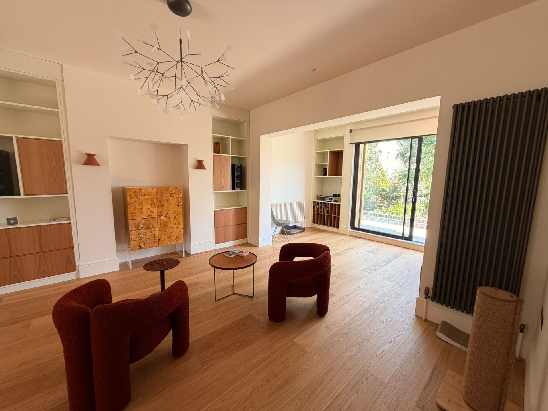 Second reception room with sculptural pendant, wall lights and built-in shelving